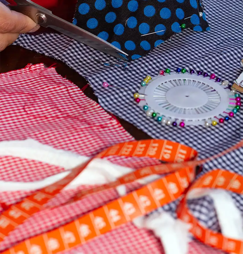 Varias telas vichy y de lunares con herramientas de costura.